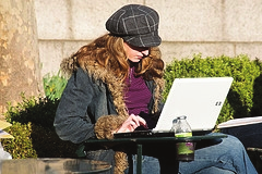 Student studying outdoors with laptop.